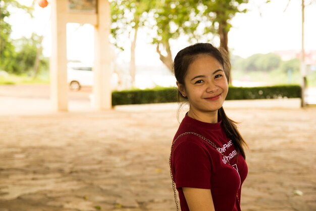 Foto retrato de una mujer sonriente de pie al aire libre