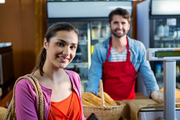 Retrato de mujer sonriente de pie cerca del mostrador de pago