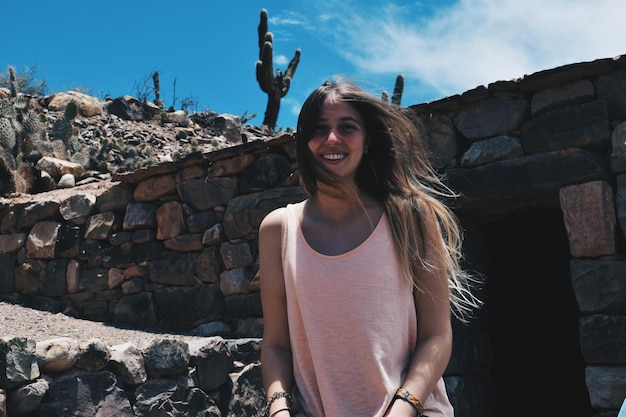 Foto retrato de una mujer sonriente de pie contra el cielo