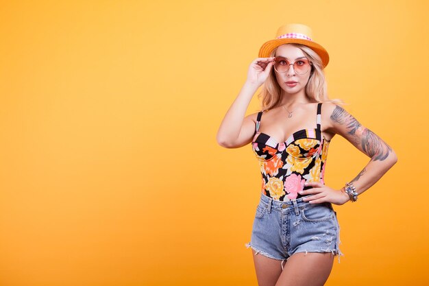 Foto retrato de una mujer sonriente de pie contra un fondo amarillo