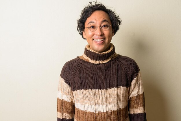 Foto retrato de una mujer sonriente de pie contra la pared