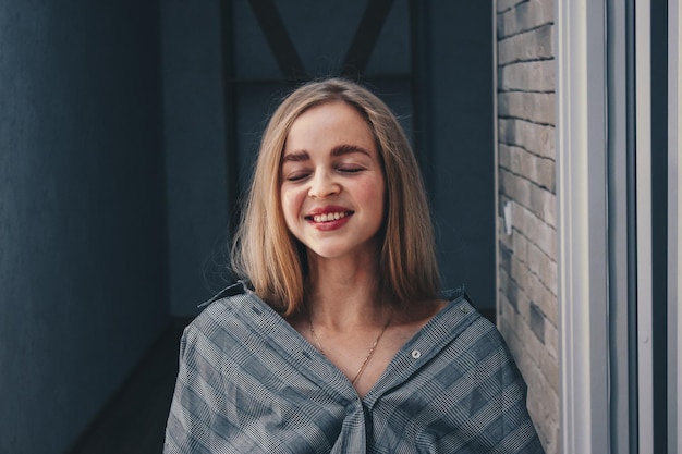 Retrato de una mujer sonriente de pie contra la pared