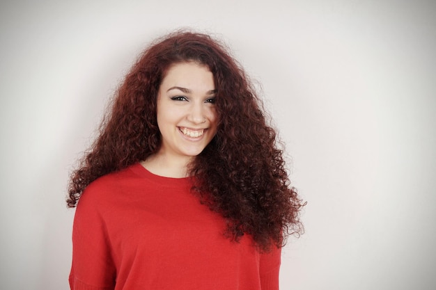 Retrato de una mujer sonriente de pie contra la pared