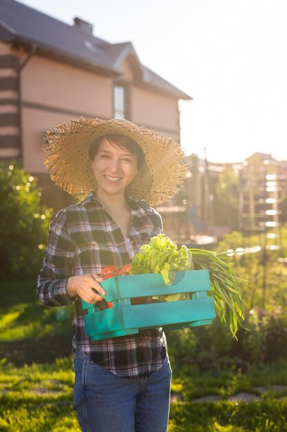 Foto retrato de una mujer sonriente de pie contra las plantas