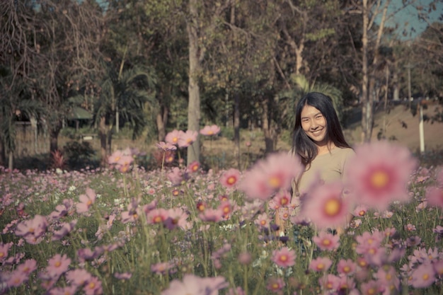 Foto retrato de una mujer sonriente de pie en medio de flores
