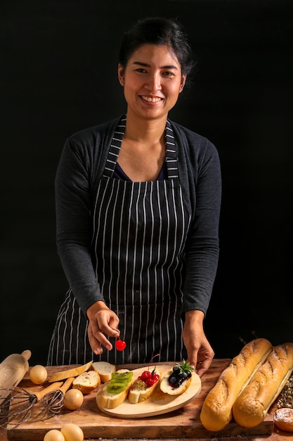 Retrato de una mujer sonriente preparando comida en la mesa