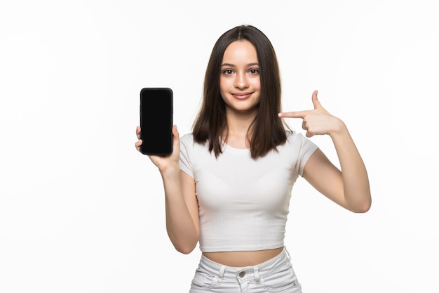 Retrato de una mujer sonriente que muestra la pantalla del teléfono inteligente en blanco sobre un fondo blanco