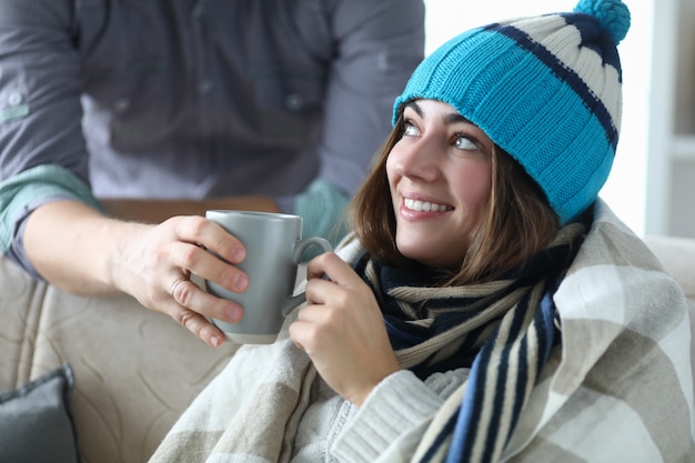 Retrato de mujer sonriente recibiendo una taza caliente de deliciosa bebida