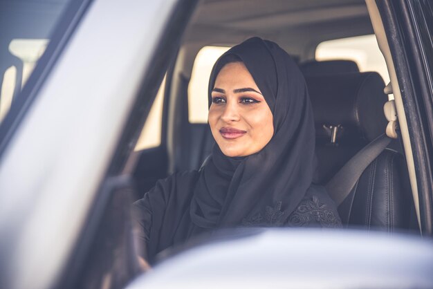 Retrato de una mujer sonriente sentada en un coche