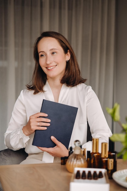 Retrato de una mujer sonriente sentada en un sillón Un aromaterapeuta con una blusa blanca está sentado en la oficina