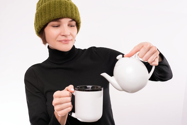 Retrato de una mujer sonriente sirviendo té de una tetera blanca. Ceremonia del té. Técnica mixta