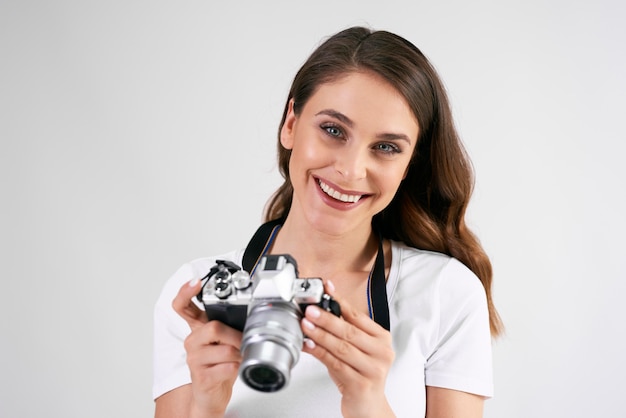 Foto retrato de mujer sonriente sosteniendo una cámara