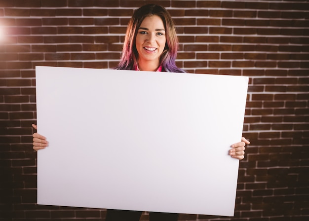 Retrato de mujer sonriente sosteniendo carteles en blanco