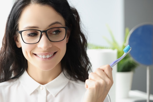 Foto retrato de mujer sonriente sosteniendo el concepto de higiene bucal cepillo de dientes