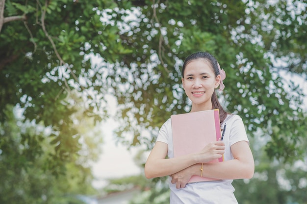 Foto retrato de una mujer sonriente sosteniendo una planta