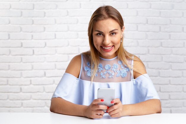 Foto retrato de una mujer sonriente con teléfono inteligente