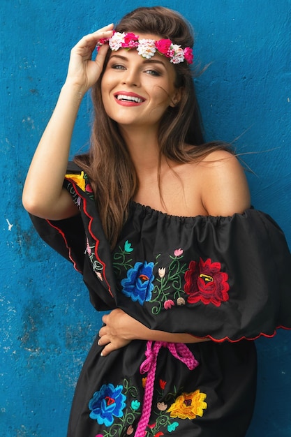 Foto retrato de una mujer sonriente con una tiara contra la pared