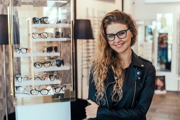 Retrato de la mujer sonriente en tienda óptica.