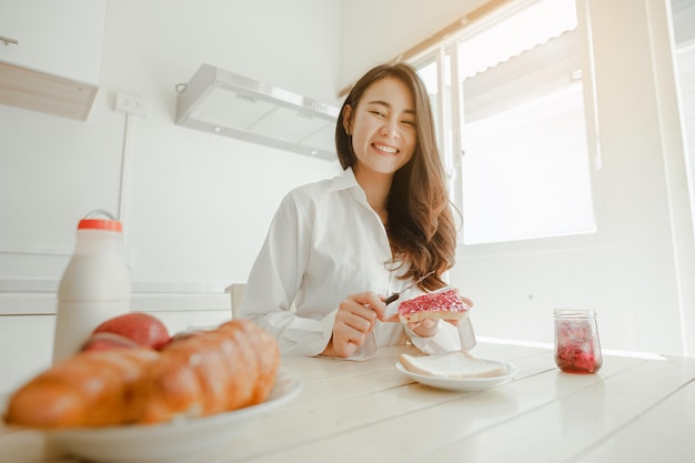 Foto retrato de una mujer sonriente tomando el desayuno