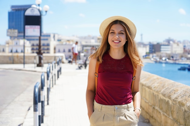 Retrato de mujer sonriente viajero caminando relajado en el paseo marítimo