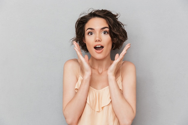 Retrato de una mujer sorprendida con las manos en la cara