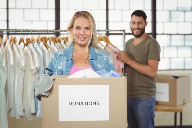 Retrato de mujer sosteniendo la caja de donación mientras está de pie