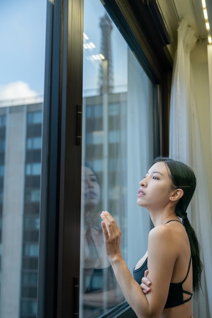 Retrato de mujer en sujetador deportivo negro en el hotel de la ventana de la luz del sol de la mañana