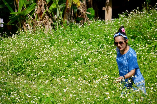 Retrato de mujer tailandesa con campo de flor de aguja española en el pueblo de Baan Natong en Phare Tailandia