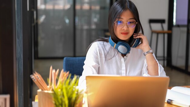 Retrato de una mujer con un teléfono inteligente en la mesa