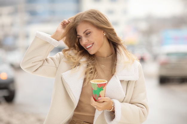 Retrato de mujer tomando café en invierno al aire libre.