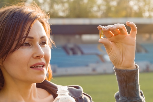 Retrato de mujer tomando cápsula de vitamina E