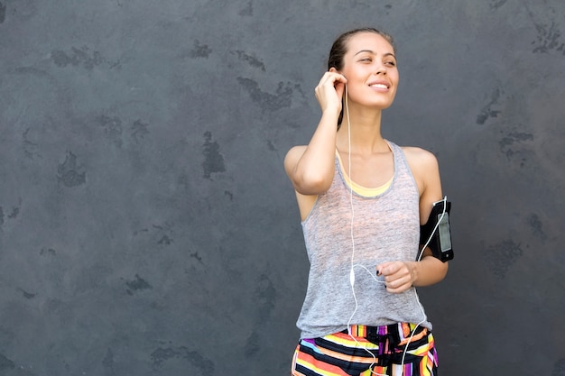 Retrato de mujer tomando descanso de correr por la pared