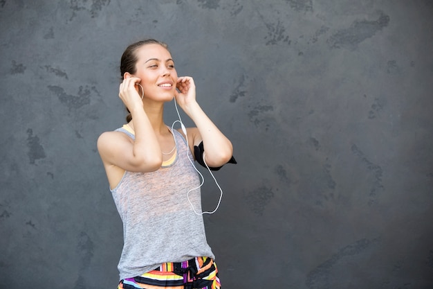 Retrato de mujer tomando descanso de correr por la pared