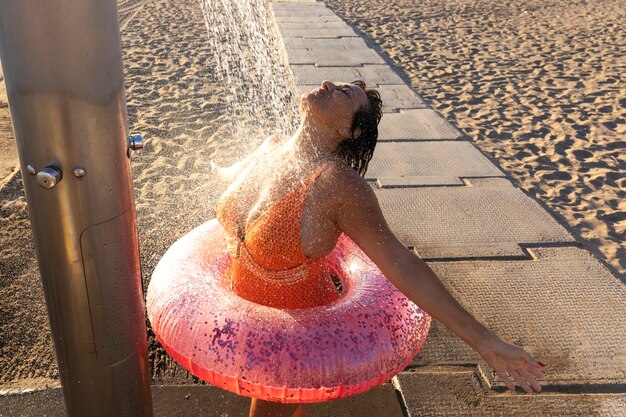 Foto retrato, de, mujer, tomar, un, ducha, en la playa