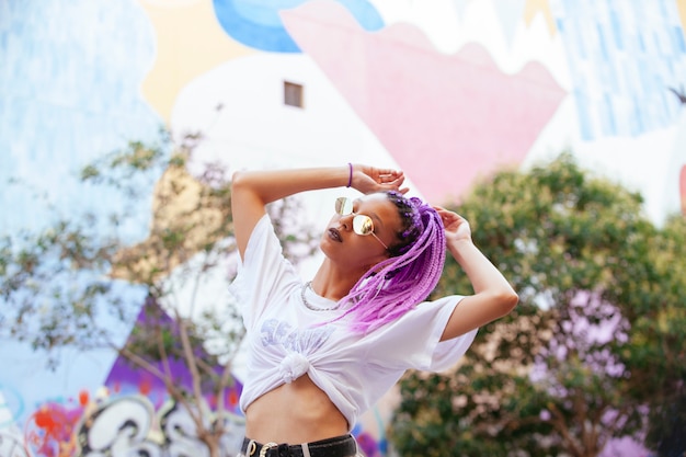 Foto retrato de una mujer con trenzas violetas y piel oscura