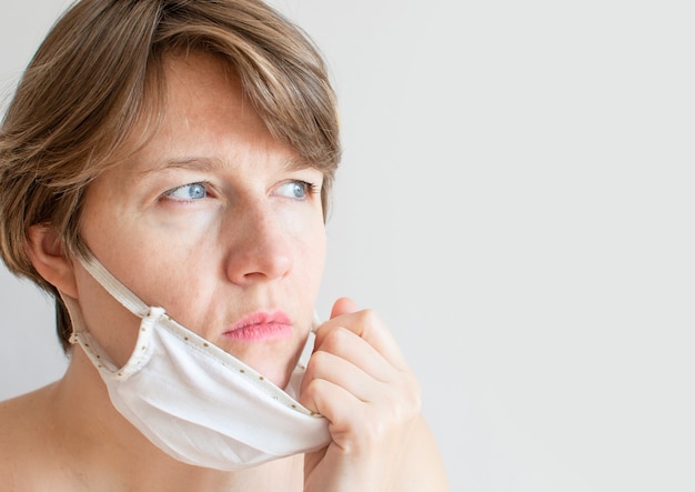 Retrato de una mujer triste con una máscara médica debido a la epidemia de coronavirus.