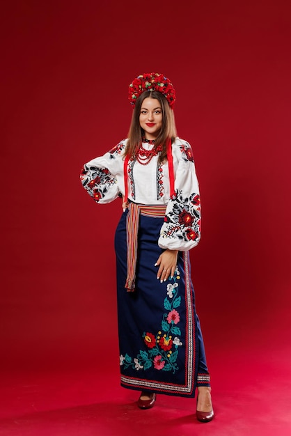 Retrato de mujer ucraniana en ropa étnica tradicional y corona floral roja sobre fondo de estudio viva magenta Vestido bordado nacional ucraniano llamada vyshyvanka Ore por Ucrania