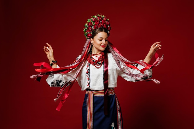 Retrato de mujer ucraniana en ropa étnica tradicional y corona floral roja sobre fondo de estudio viva magenta Vestido bordado nacional ucraniano llamada vyshyvanka Ore por Ucrania