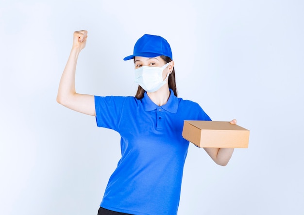 Retrato de mujer en uniforme y máscara médica con caja de papel