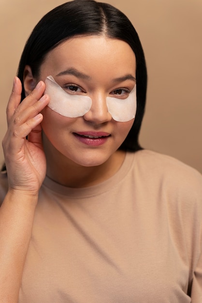 Foto retrato de mujer usando parches en los ojos para el cuidado de la piel