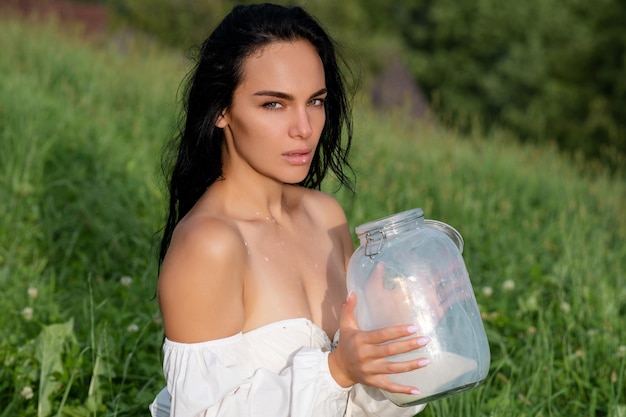 Foto retrato de una mujer con una vaca de leche salpicada una chica en una granja belleza chica romántica bebiendo leche cerca de suiza