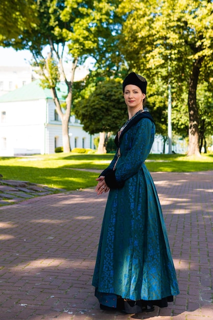 Retrato de mujer vestida con ropa barroca histórica azul con peinado de moda antigua al aire libre