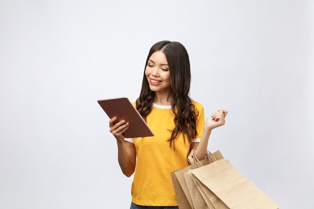 Retrato de mujer en vestido de verano sosteniendo bolsas de paquetes con compras después de las compras en línea