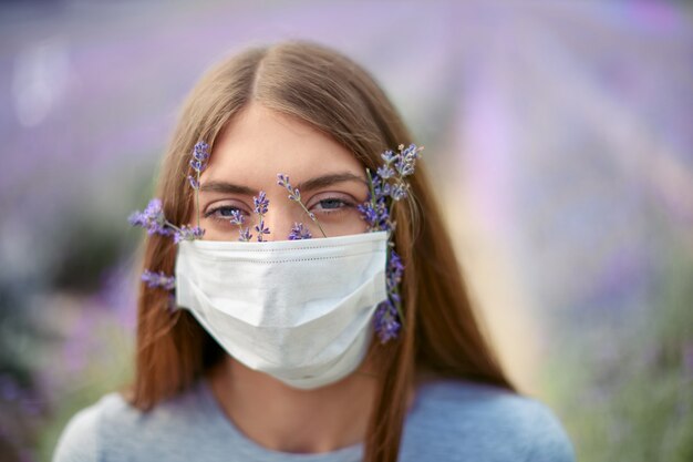 Retrato de mujer vistiendo mascarilla con flores de lavanda