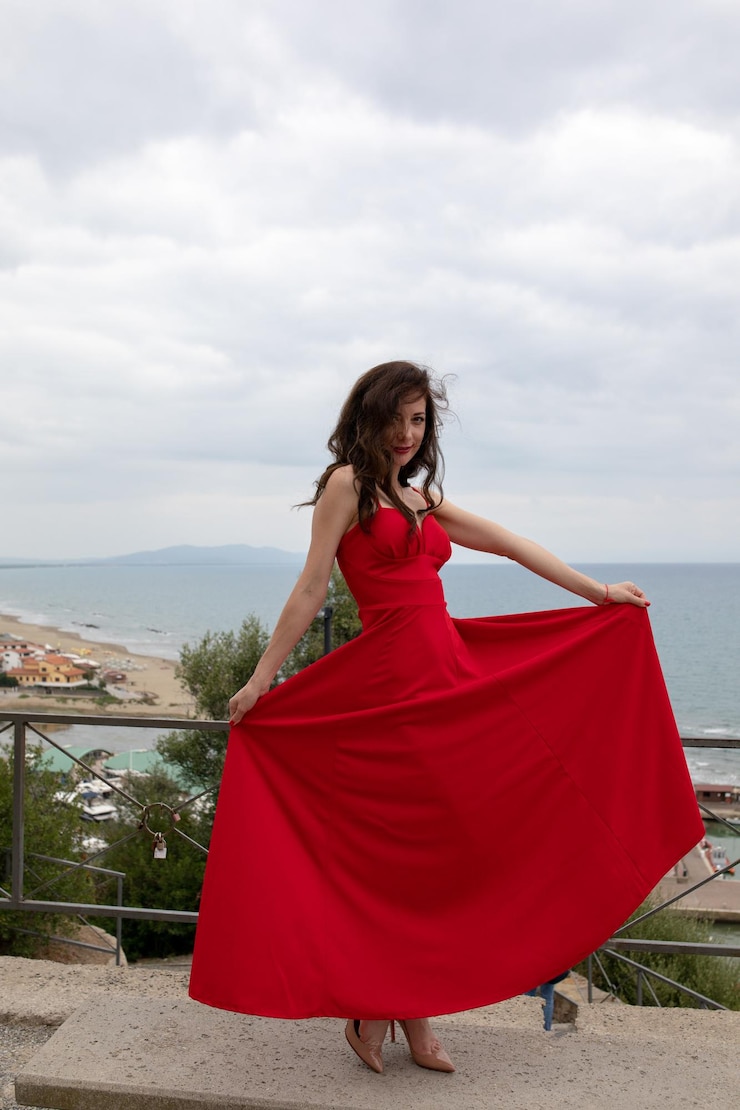 Foto retrato de mujeres hermosas sosteniendo un vestido contra el mar