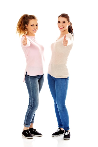 Retrato de mujeres jóvenes sonrientes gestando contra un fondo blanco