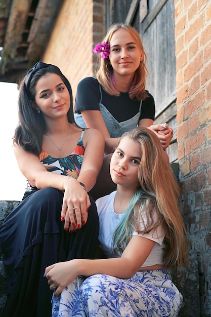 Retrato de mujeres jóvenes sonrientes sentadas en las escaleras