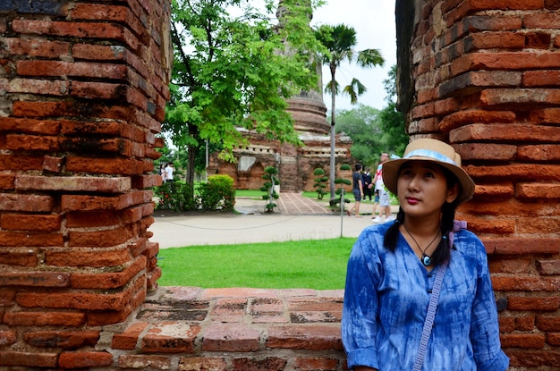 Retrato de mujeres tailandesas en la pared de ladrillo de la estatua de Buda reclinado de la Iglesia de Wat Yai chaimongkol en Ayutthaya, Tailandia