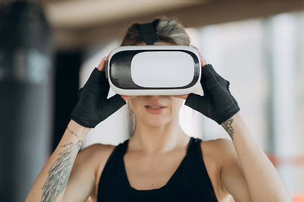 Retrato mulher atraente boxe no treinamento de fone de ouvido VR 360 para chutar em realidade virtual