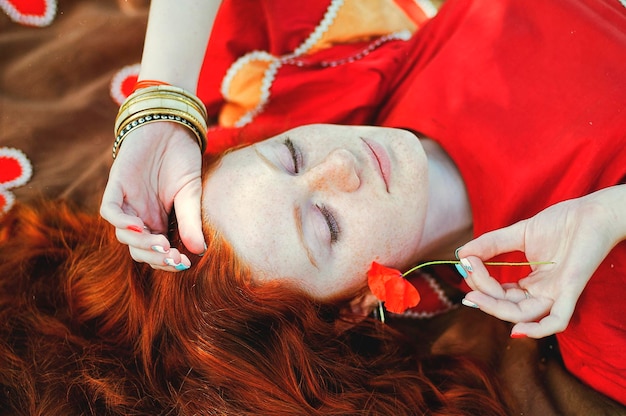 Retrato. Mulher Boho na natureza do verão. Cabelo encaracolado ruivo, sardas. Estilo de vida feliz. Atmosférico